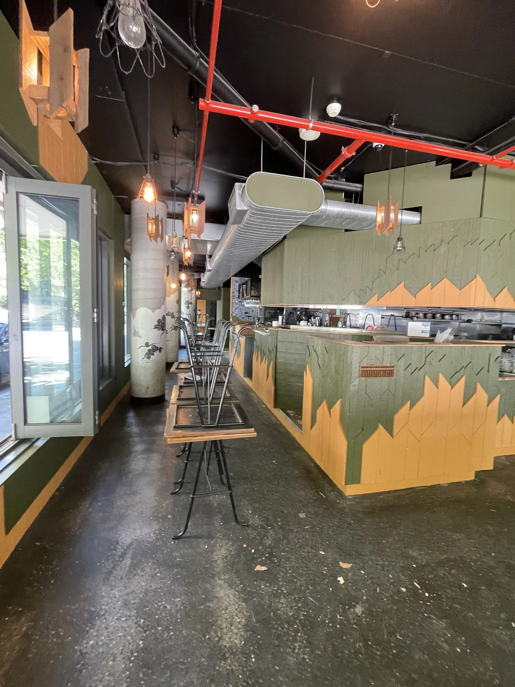A cafe counter painted in a green and orange mural pattern