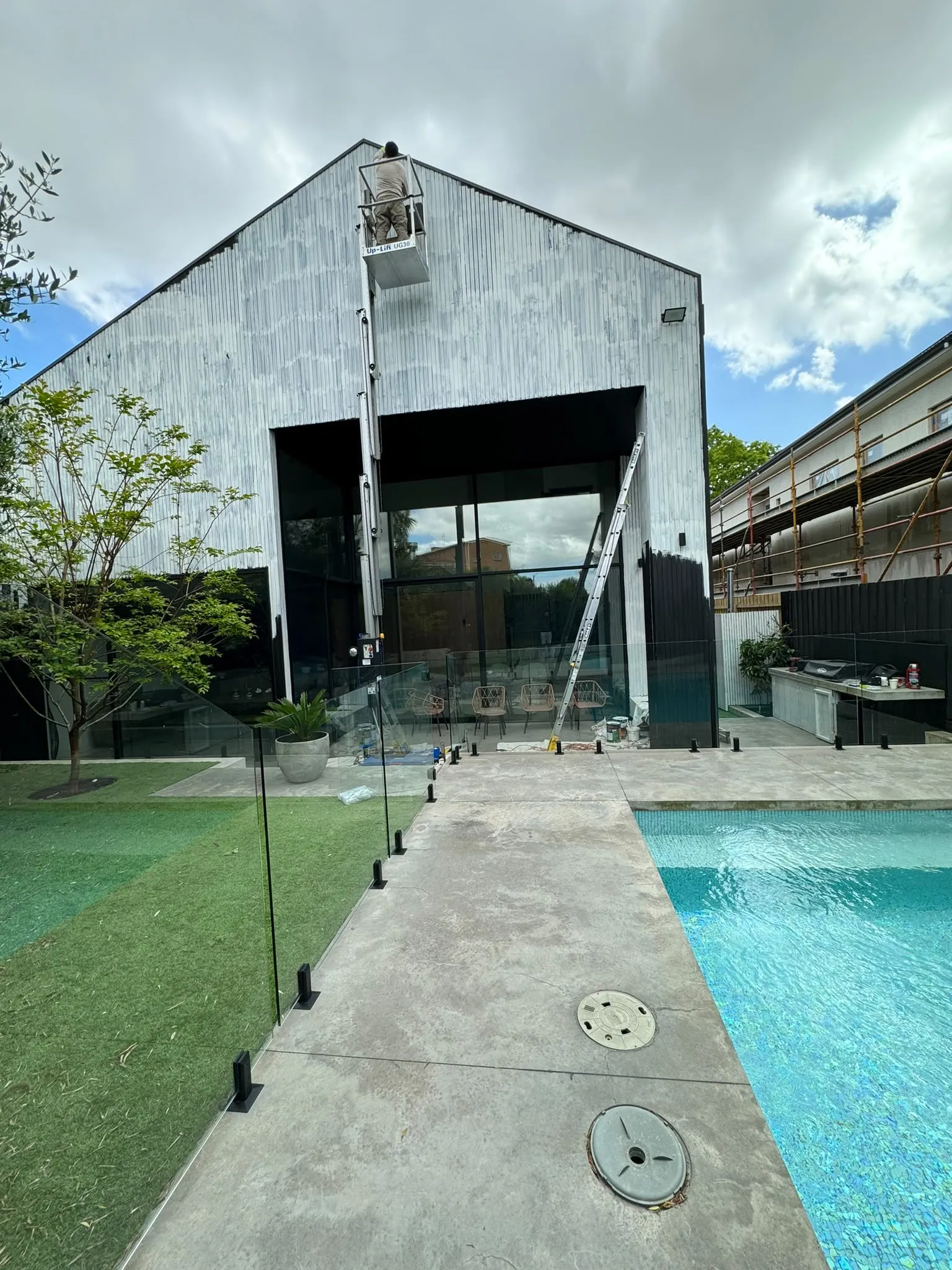 A tall building with wood siding beside a swimming pool