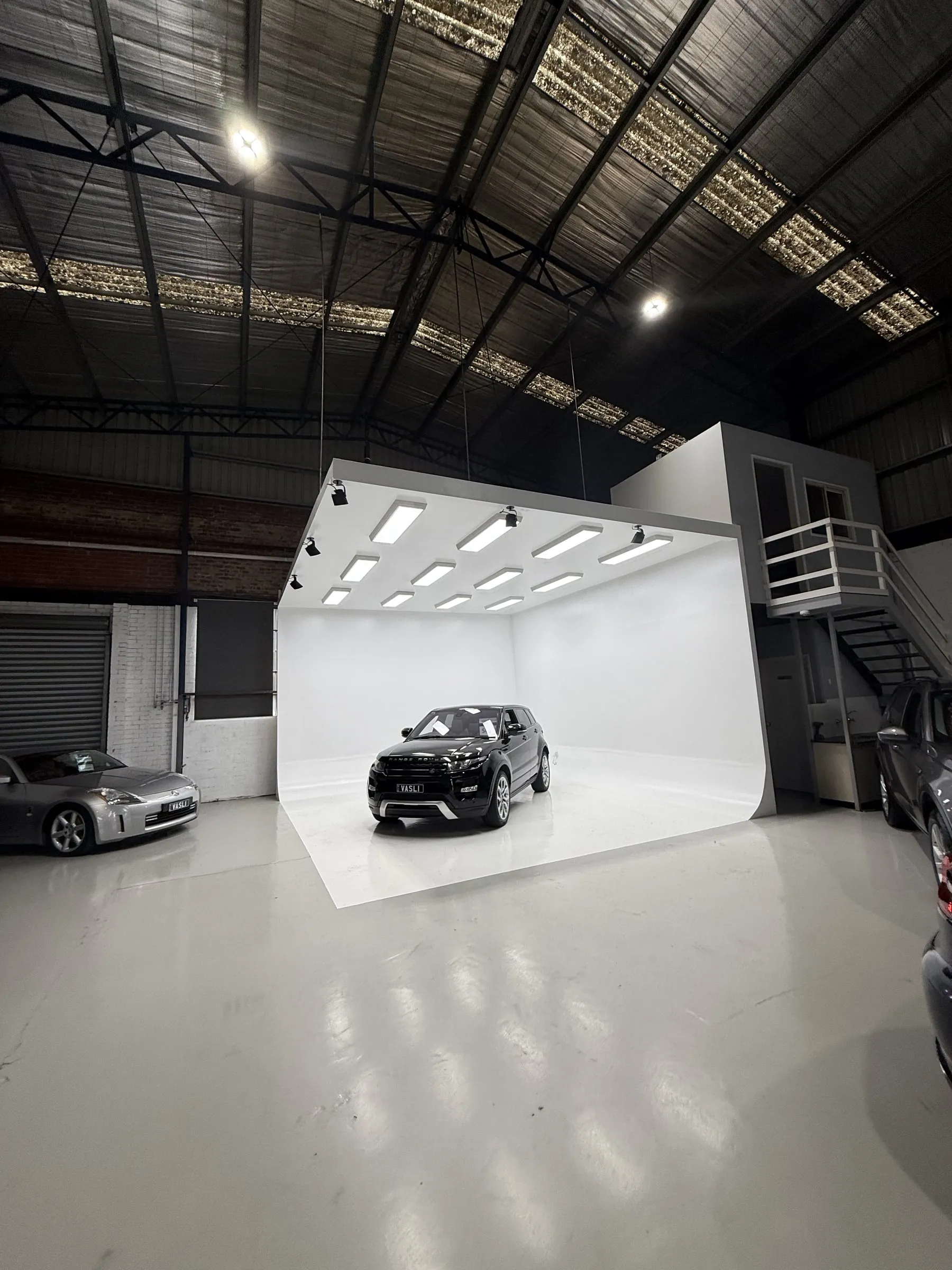 A finished white photography cove with a car parked in it