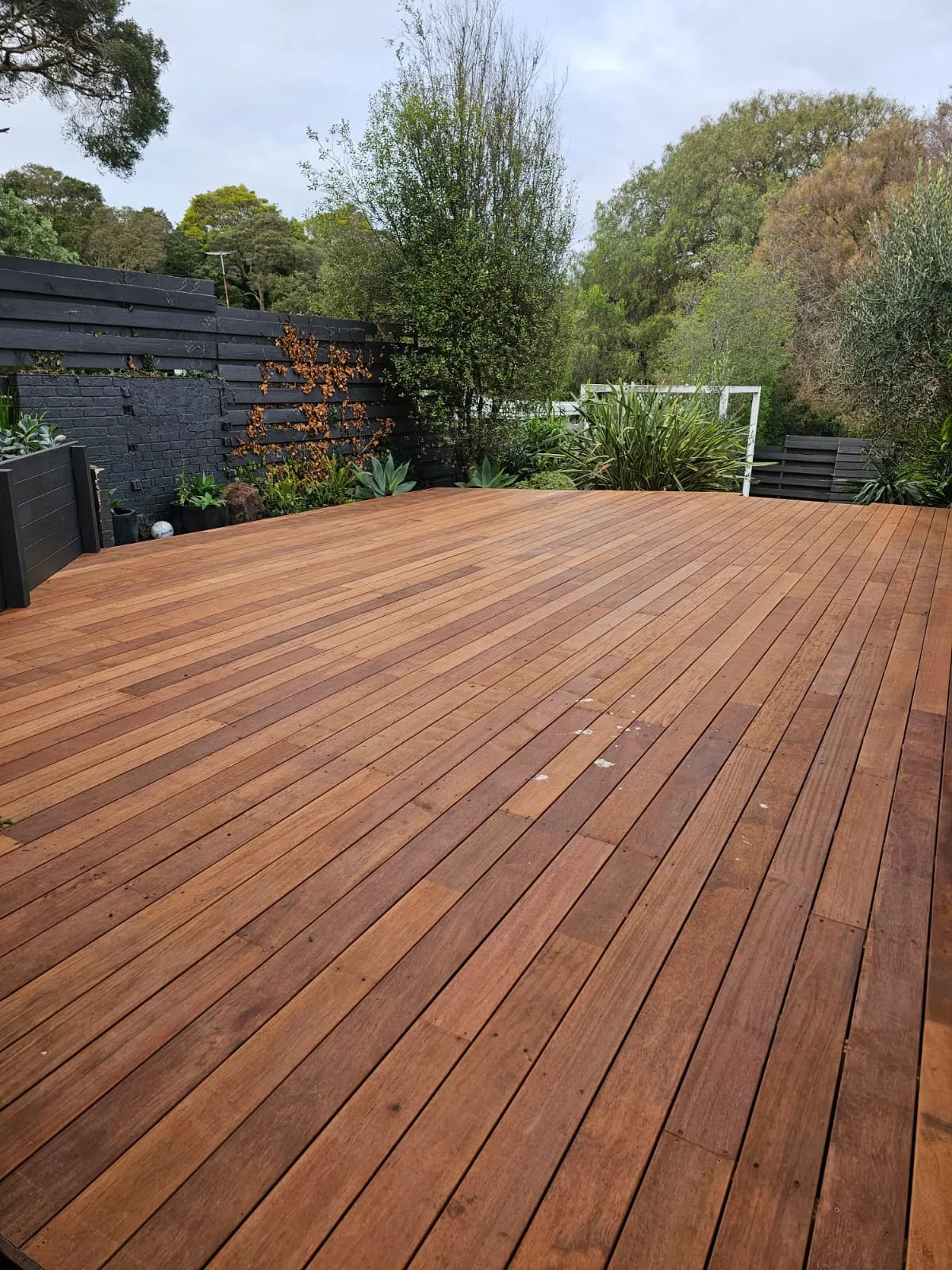 A stained wood deck in a backyard