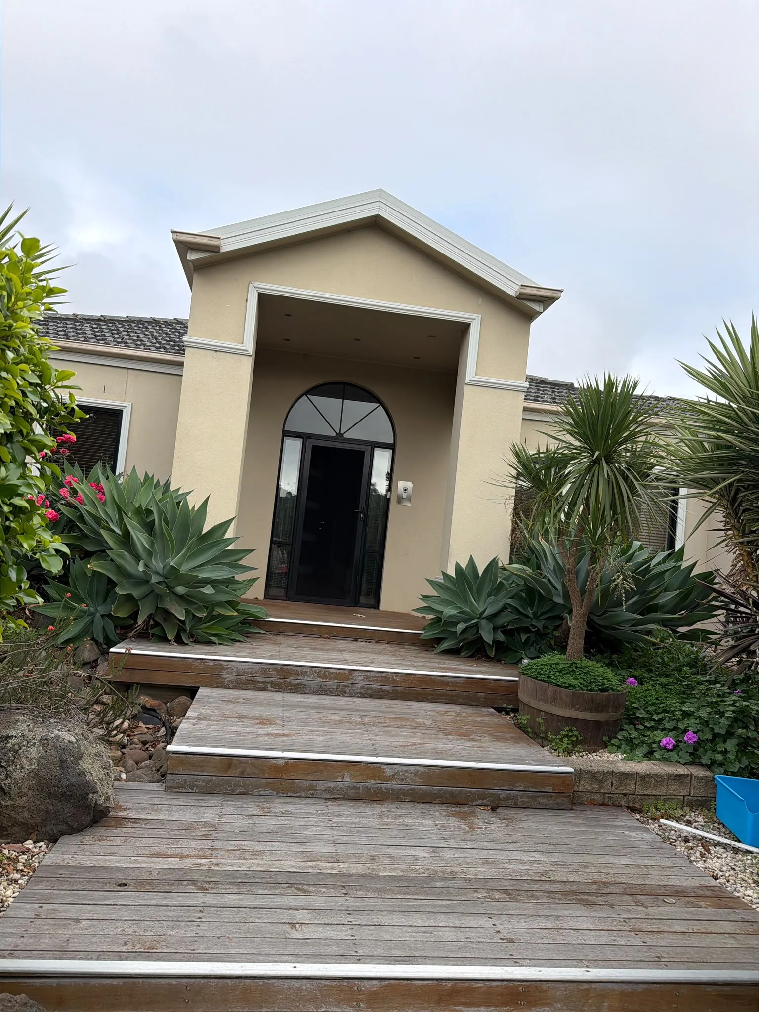 Weathered deck stairs and a gray stucco wall