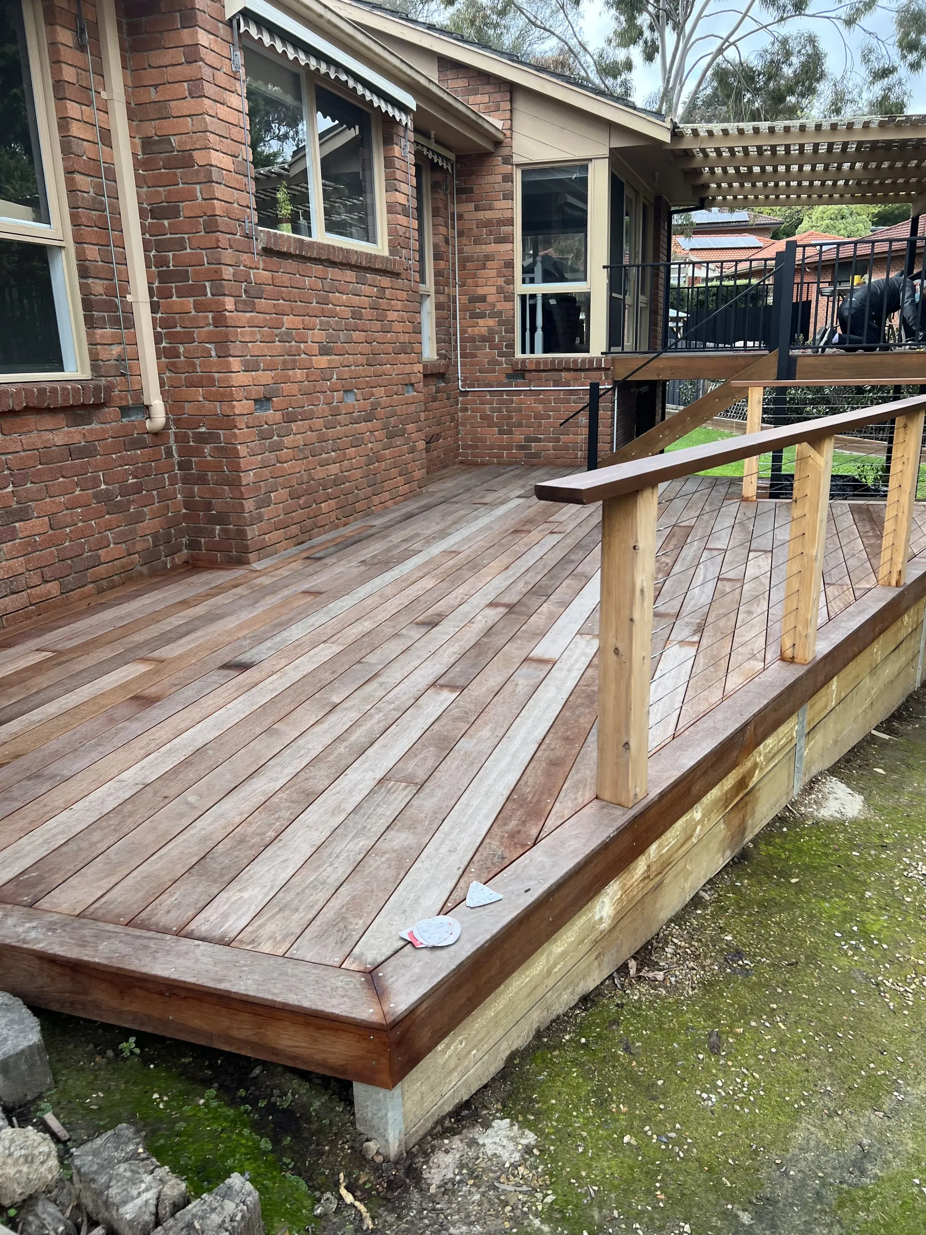 A weathered wood deck beside a brick house