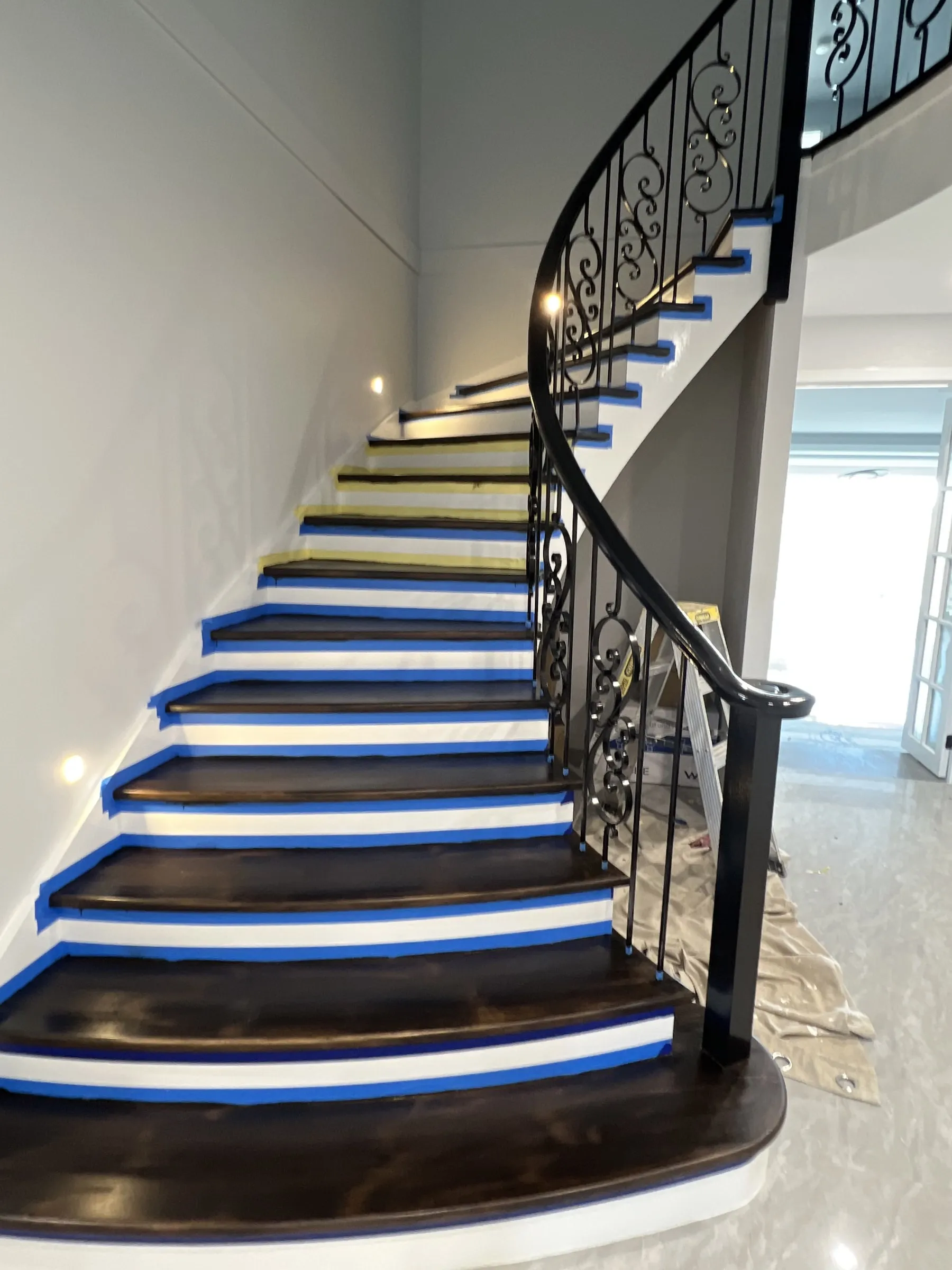 A curved staircase with stained treads and masked risers